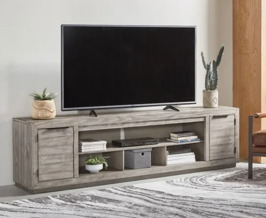 TV on rustic wood entertainment center with decor.
